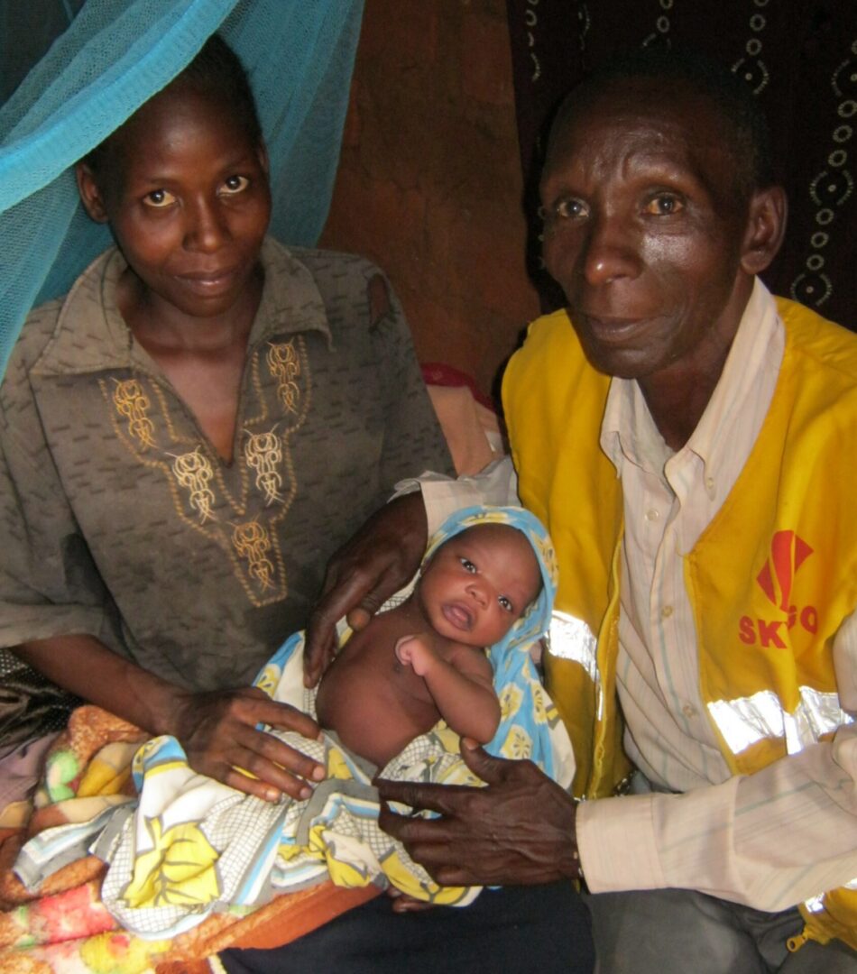 Parents holding newborn baby indoors