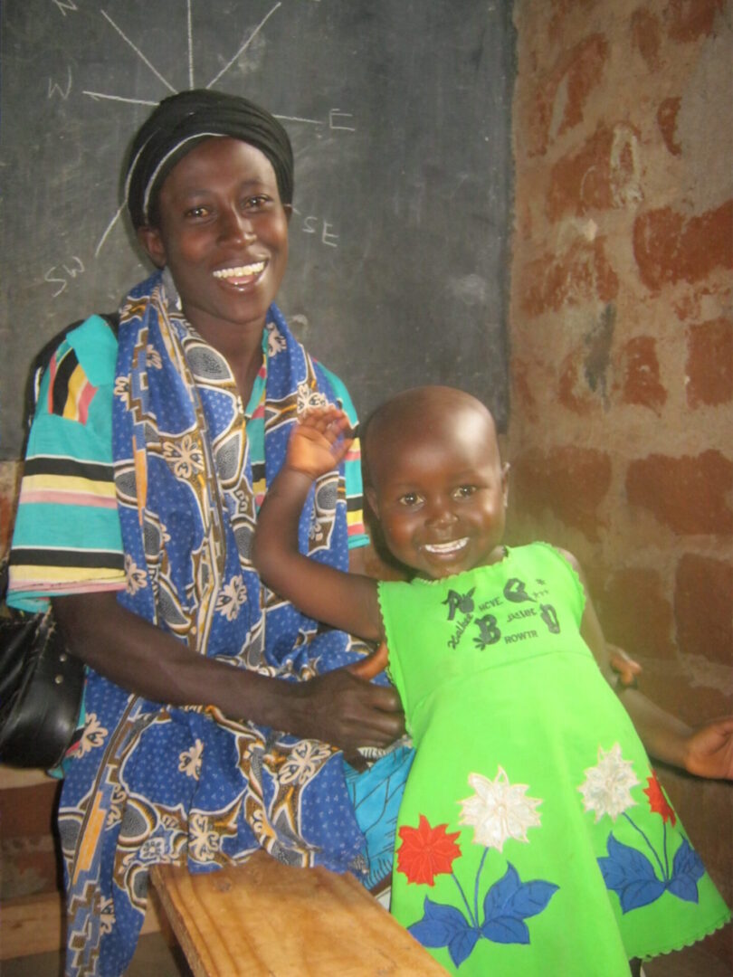 Happy child in green dress with woman