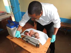 Infant being weighed by healthcare worker