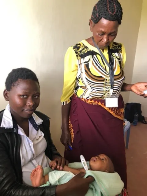 Woman holding baby with thermometer