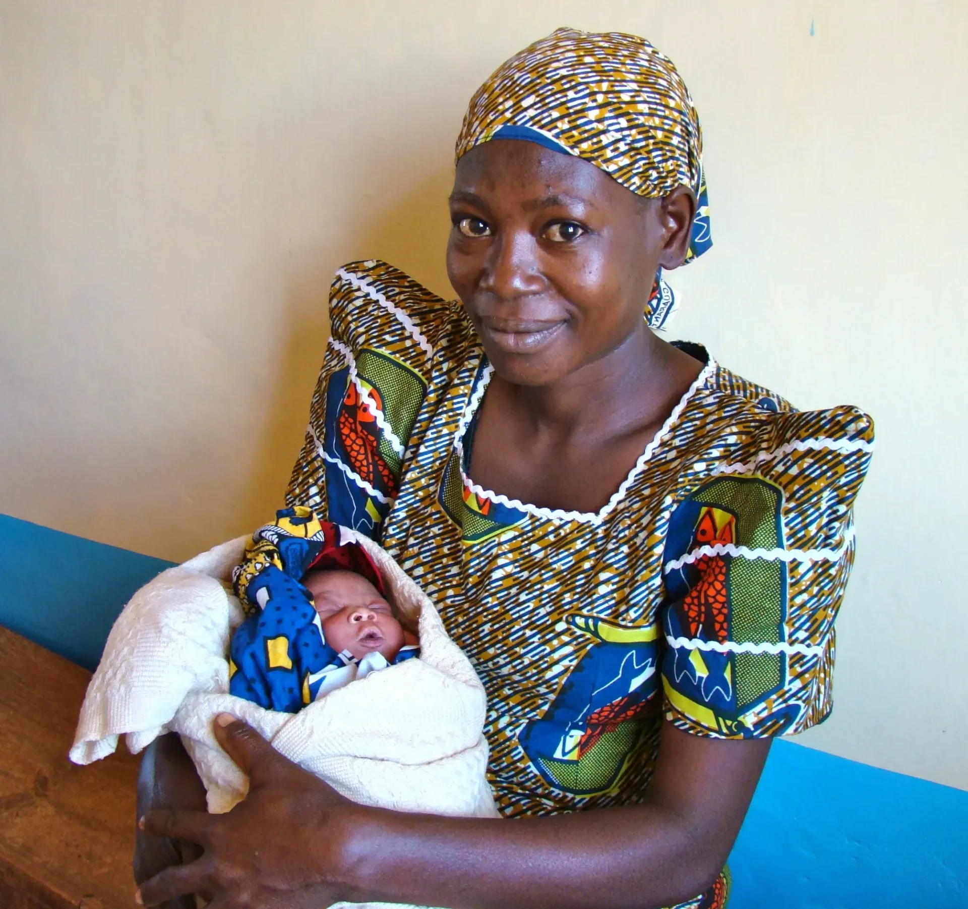 Mother smiling while holding newborn baby