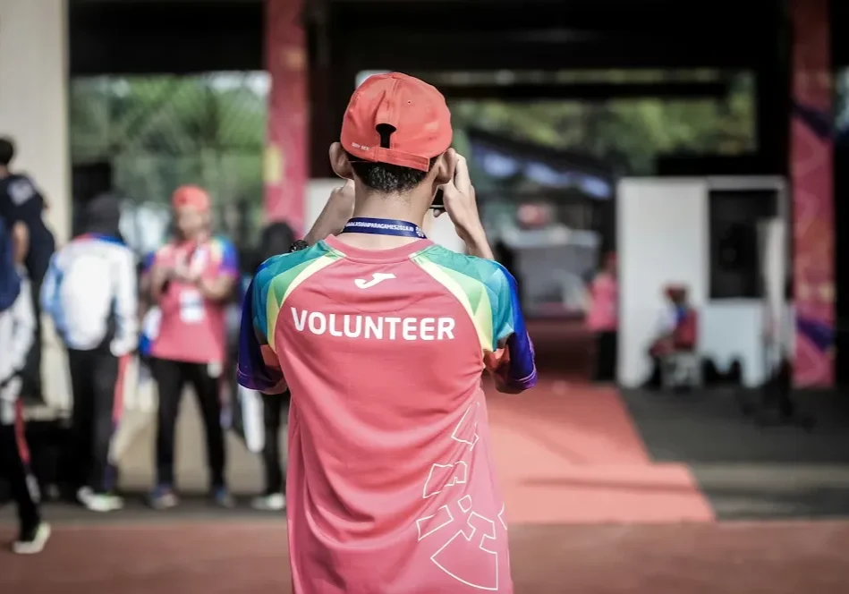 Event volunteer adjusting cap outdoors