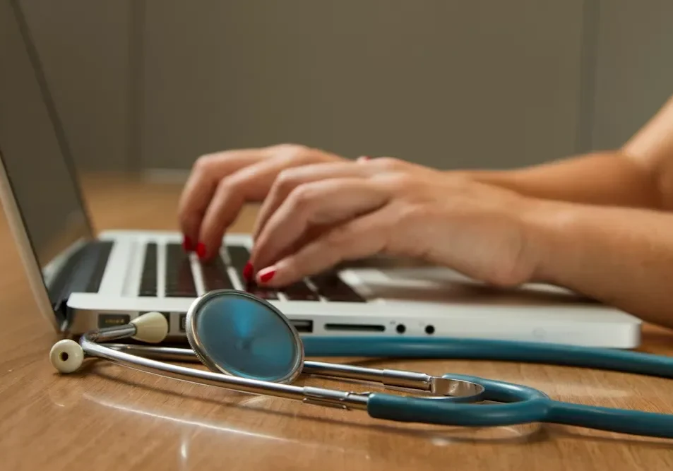 Medical professional using laptop at desk